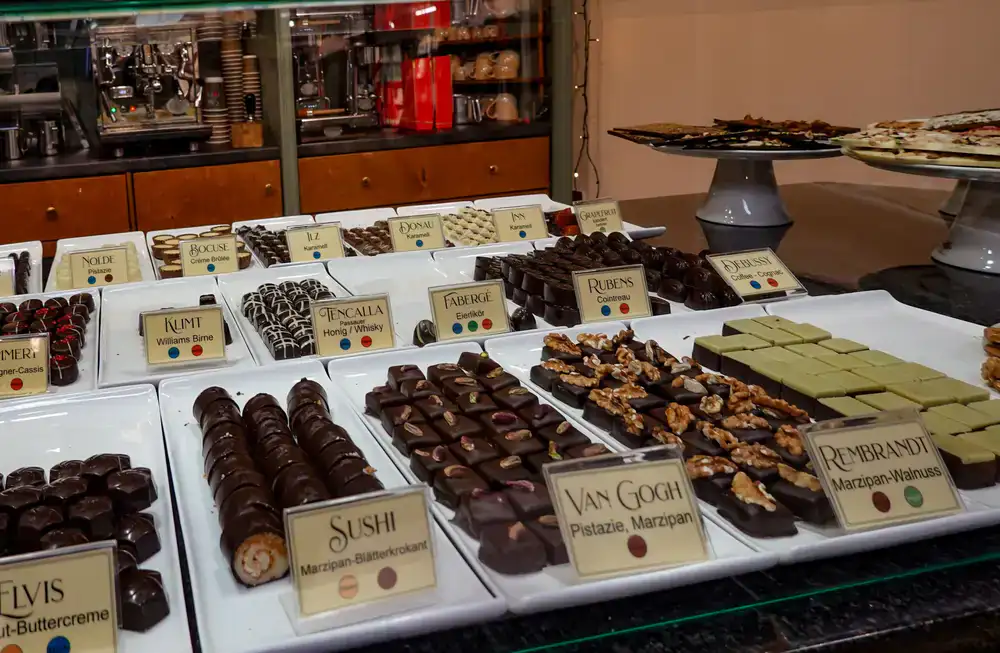Interior of a luxury food boutique displaying fine artisan chocolates in glass cabinets
